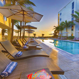 Outdoor pool area with sun setting in the distance