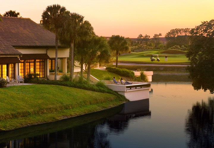 Couple sat on villa patio overlooking golf course