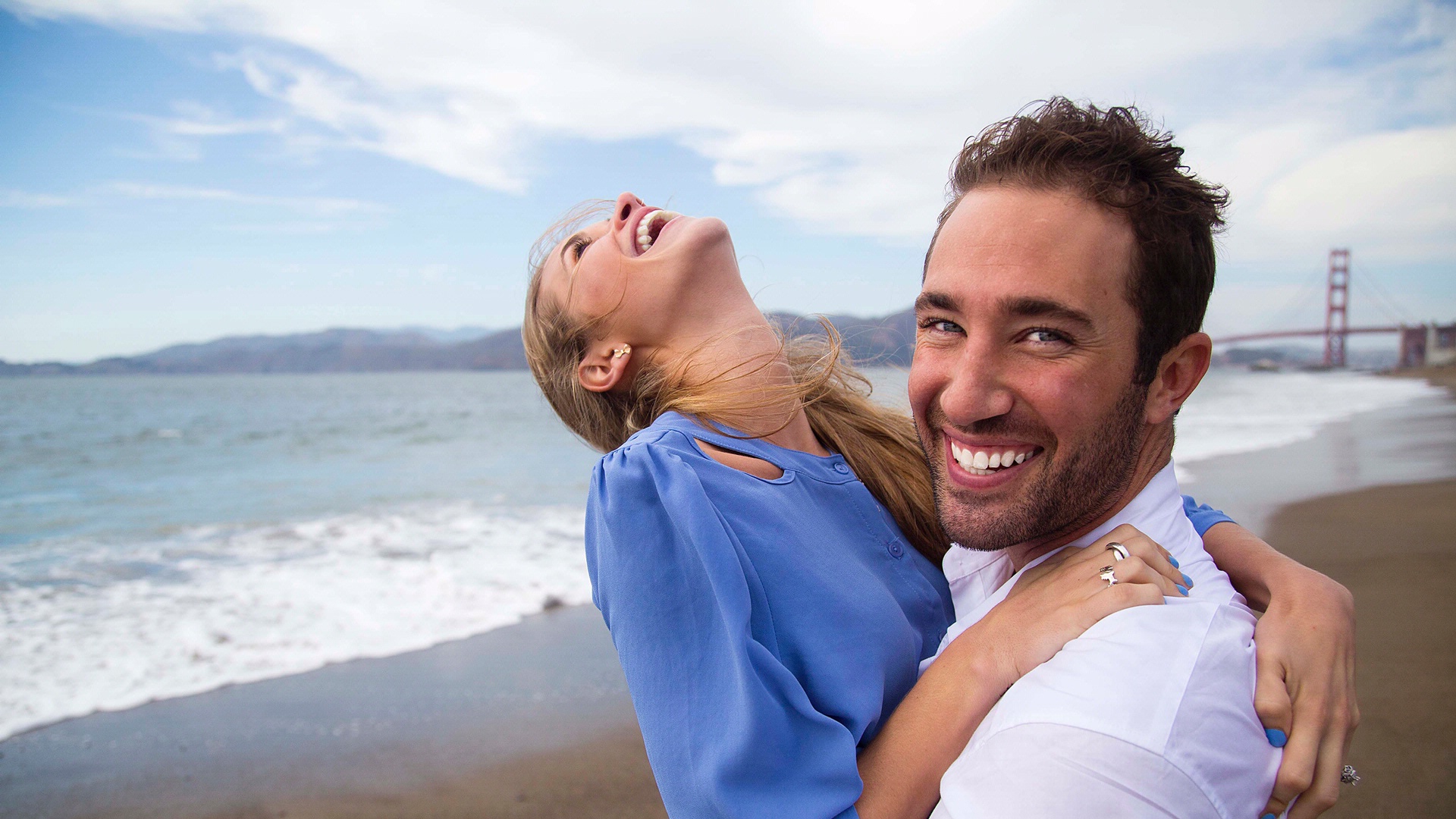 Couple smiling and hugging on the beach