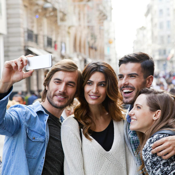 4 people smiling and taking a selfie